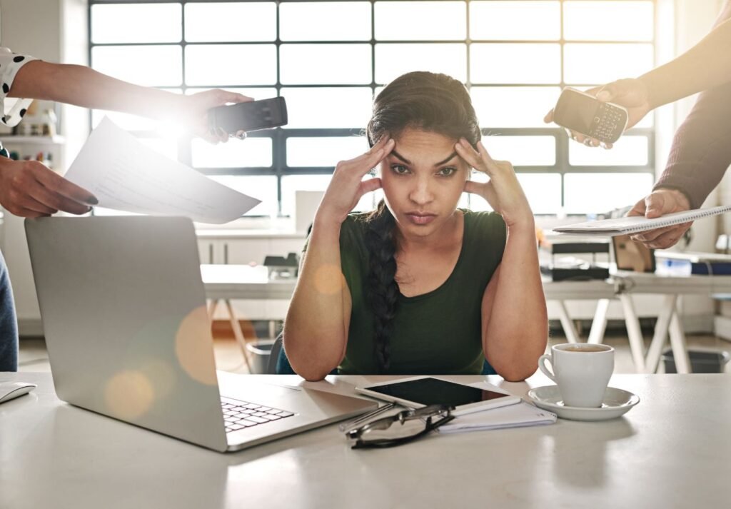 mulher em uma mesa de trabalho com varias demandas