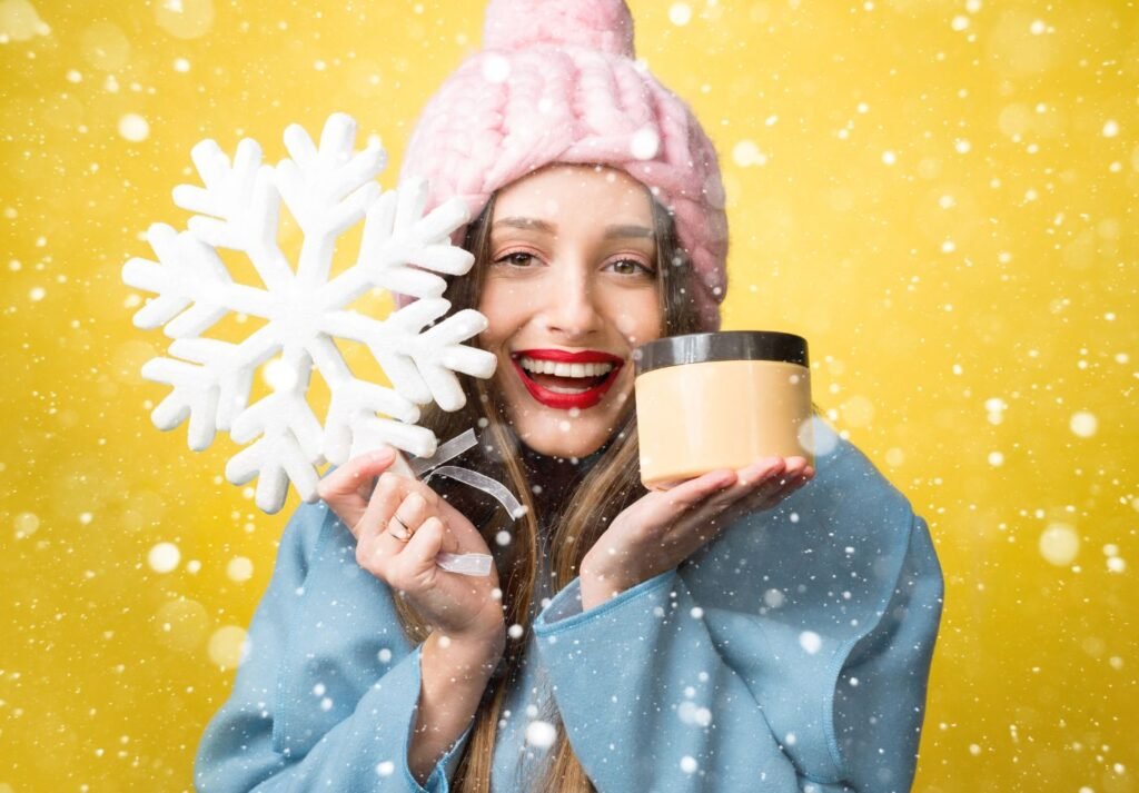 mulher com roupas de frio segurando um caneca e um pelúcia em forma de floco de gelo