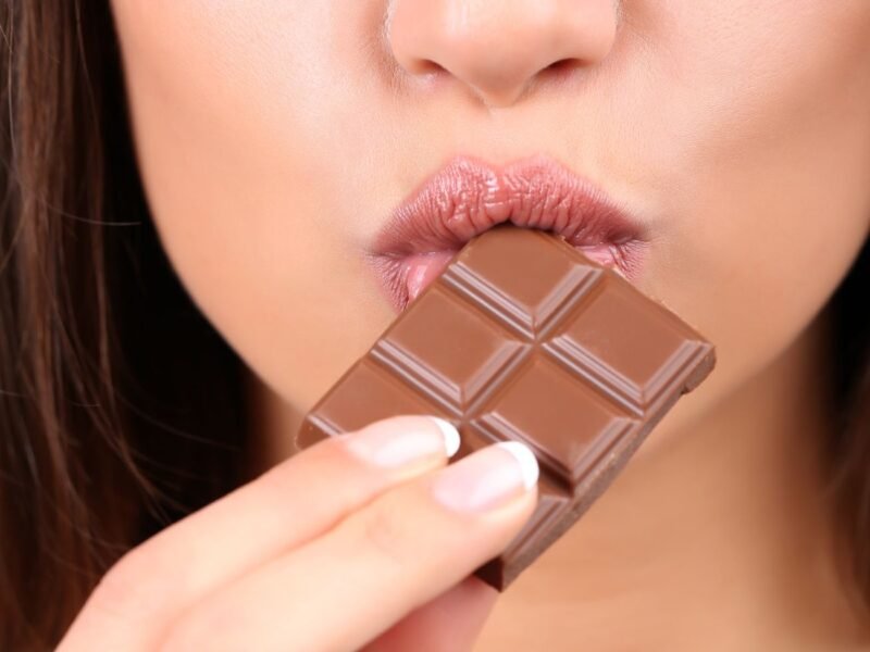 lábio de mulher sobre uma barra de chocolate ao leite