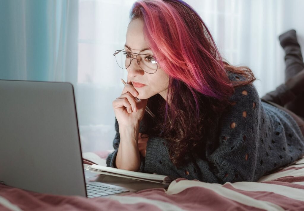 mulher trabalhando em um notebook sobre uma cama