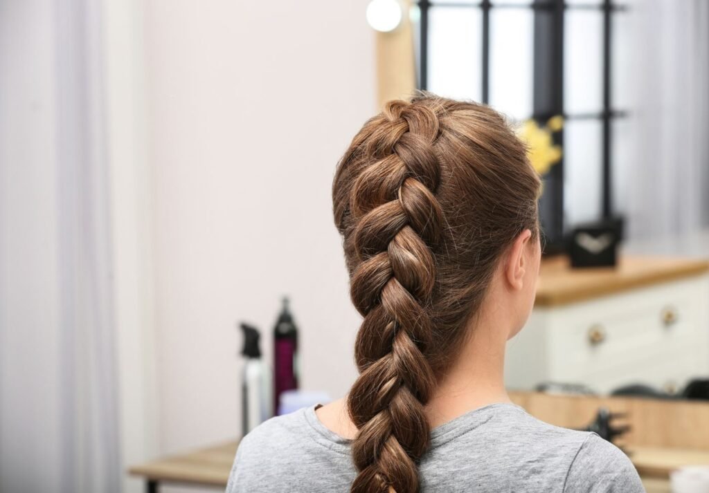 mulher de costa mostrando o corte de cabelo chamado "trança embutida"