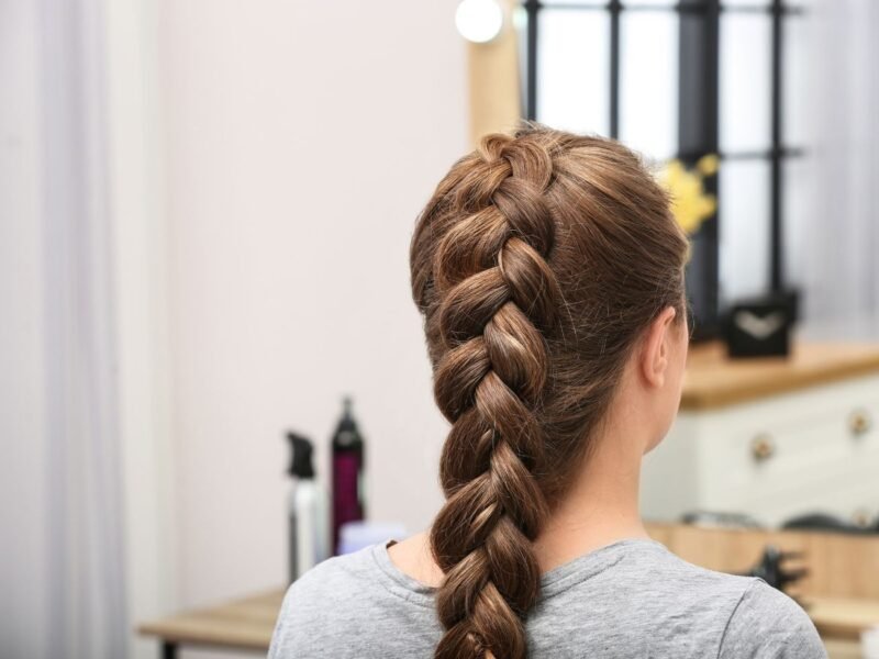 mulher de costa mostrando o corte de cabelo chamado "trança embutida"